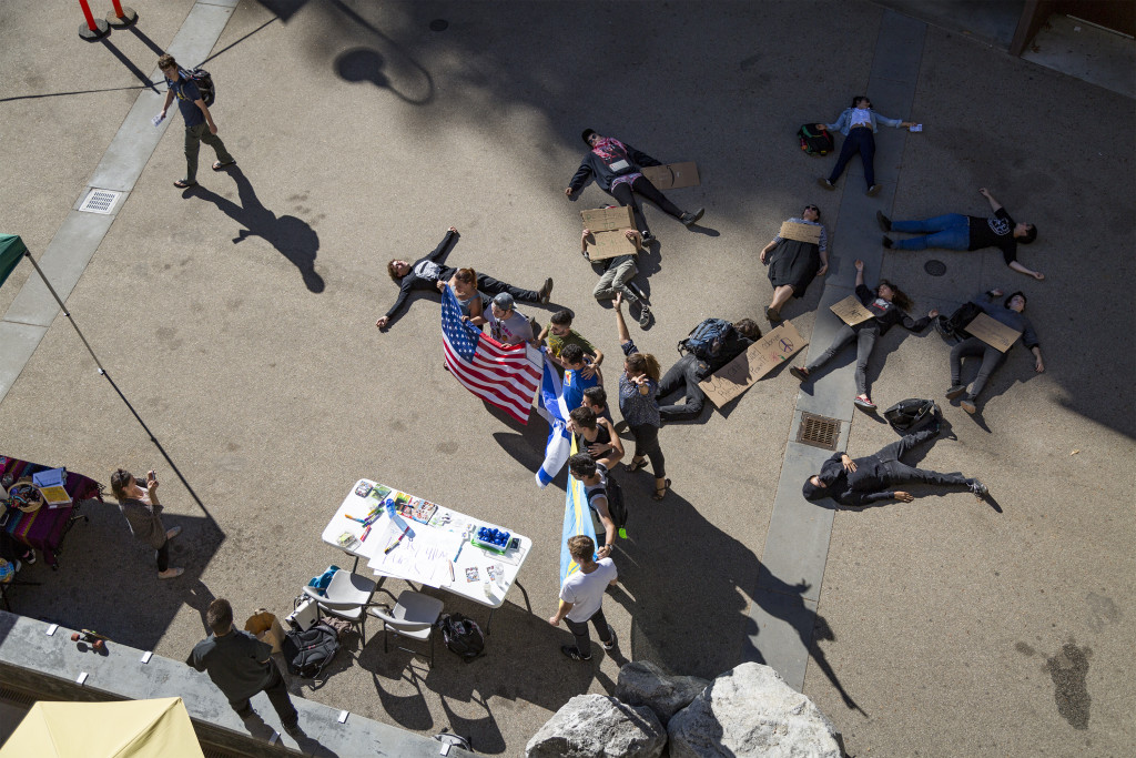 Slugs for Israel hold American and Israeli flags and pose while demonstrators lay motionless in Quarry Plaza (November 8, 2015)